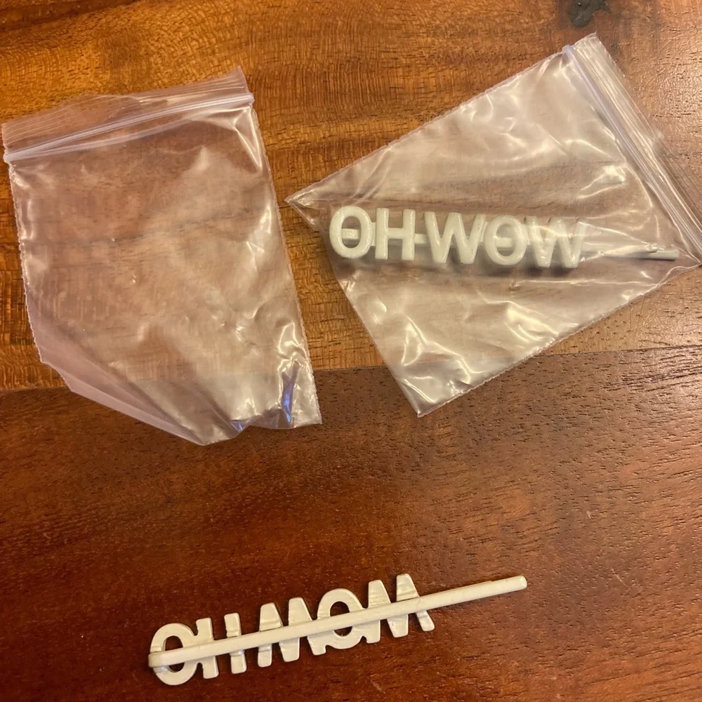 new set of two bobby pins for hair with saying “oh wow”
